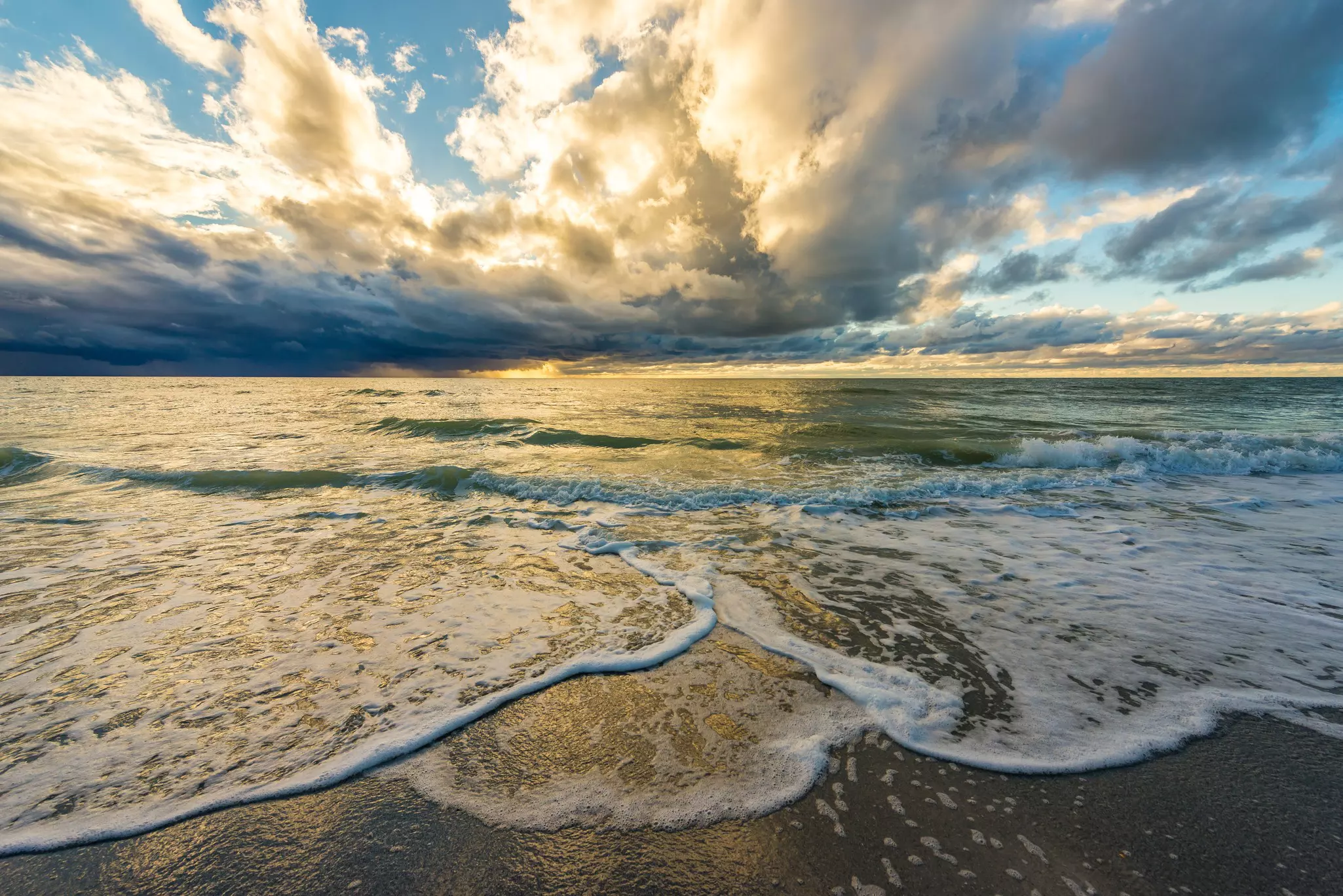 Waves crashing onto Belleair Beach at sunset.