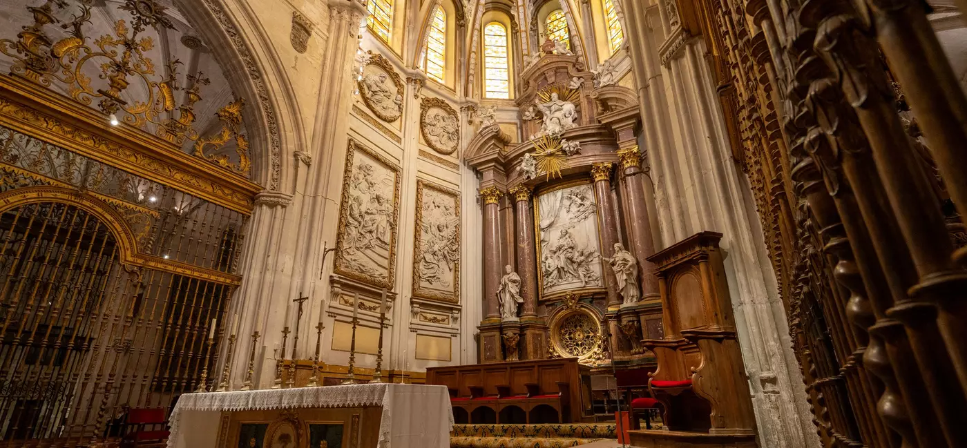 The cathedral's interior highlights Gothic vaulting, ornate altarpieces, and detailed stained glass windows. 