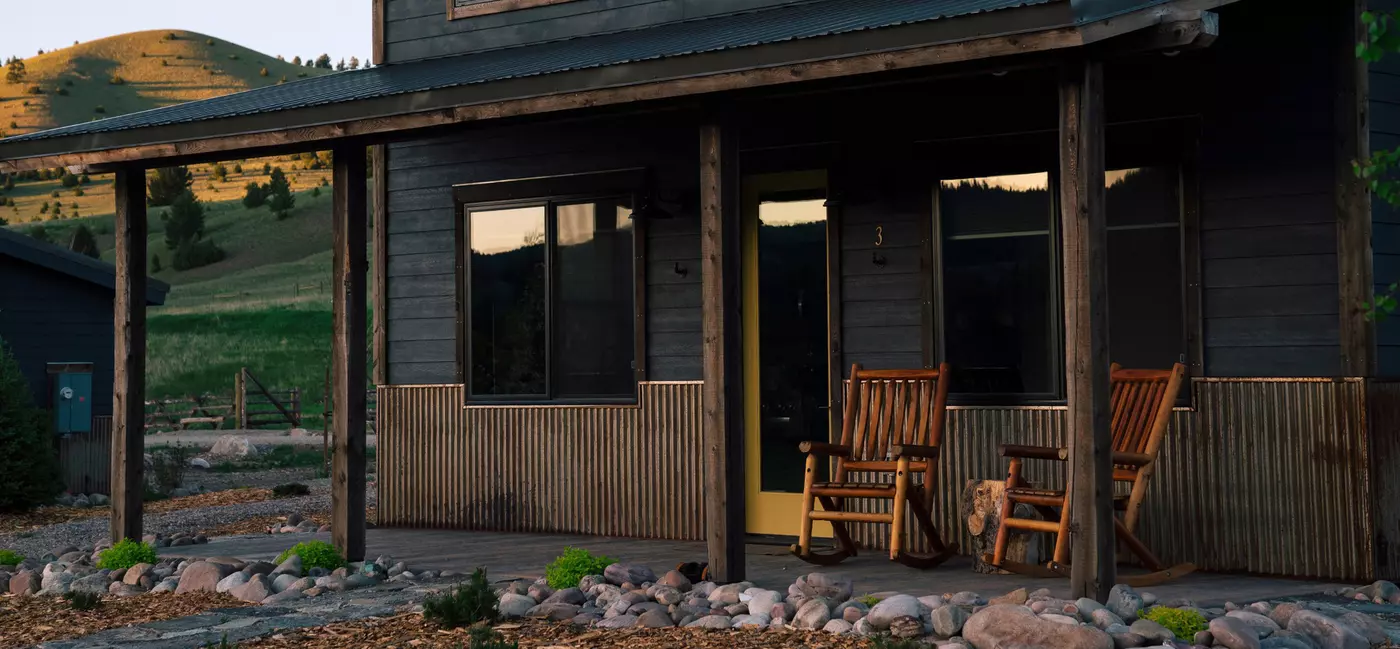 Front porch of a wooden modern cabin with two rocking chairs