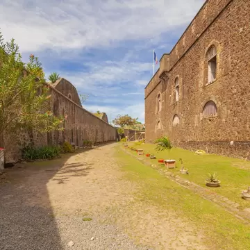 Grassy path running between the high stone walls and arched windows of Fort Napoléon on Terre-de-Haut, Les Saintes