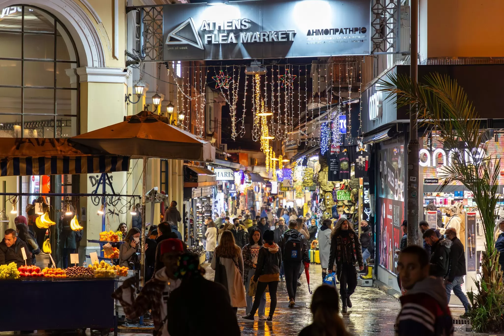 A busy flea market at night packed with people shopping