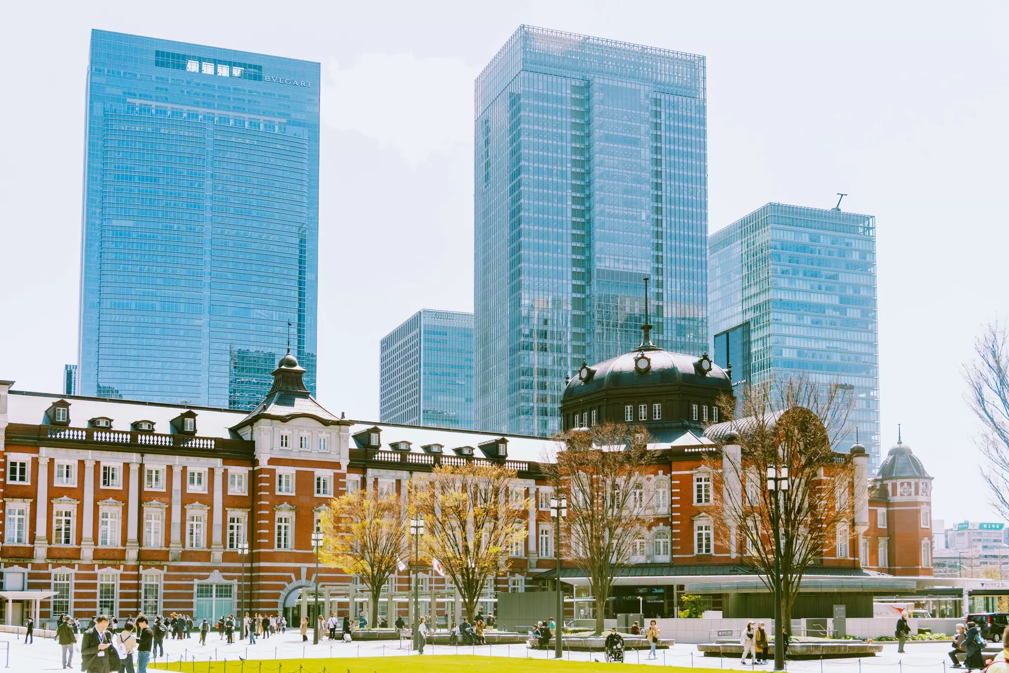 A large, stately brick building in Tokyo with glass skyscrapers in the background 