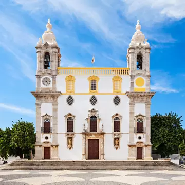 Exterior view of the Igreja de Nossa Senhora do Carmo on a sunny day in Faro, Portugal.