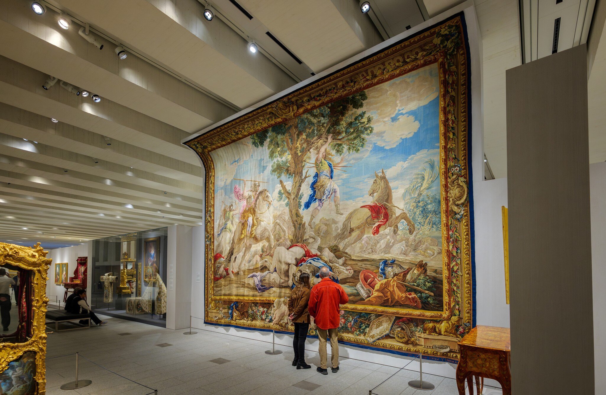 A couple admires the tapestry 'Death of Absalom,' by Real Fabrica de Tapices workshop, at the Royal Collections Gallery in Madrid, Spain.