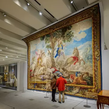 A couple admires the tapestry 'Death of Absalom,' by Real Fabrica de Tapices workshop, at the Royal Collections Gallery in Madrid, Spain.