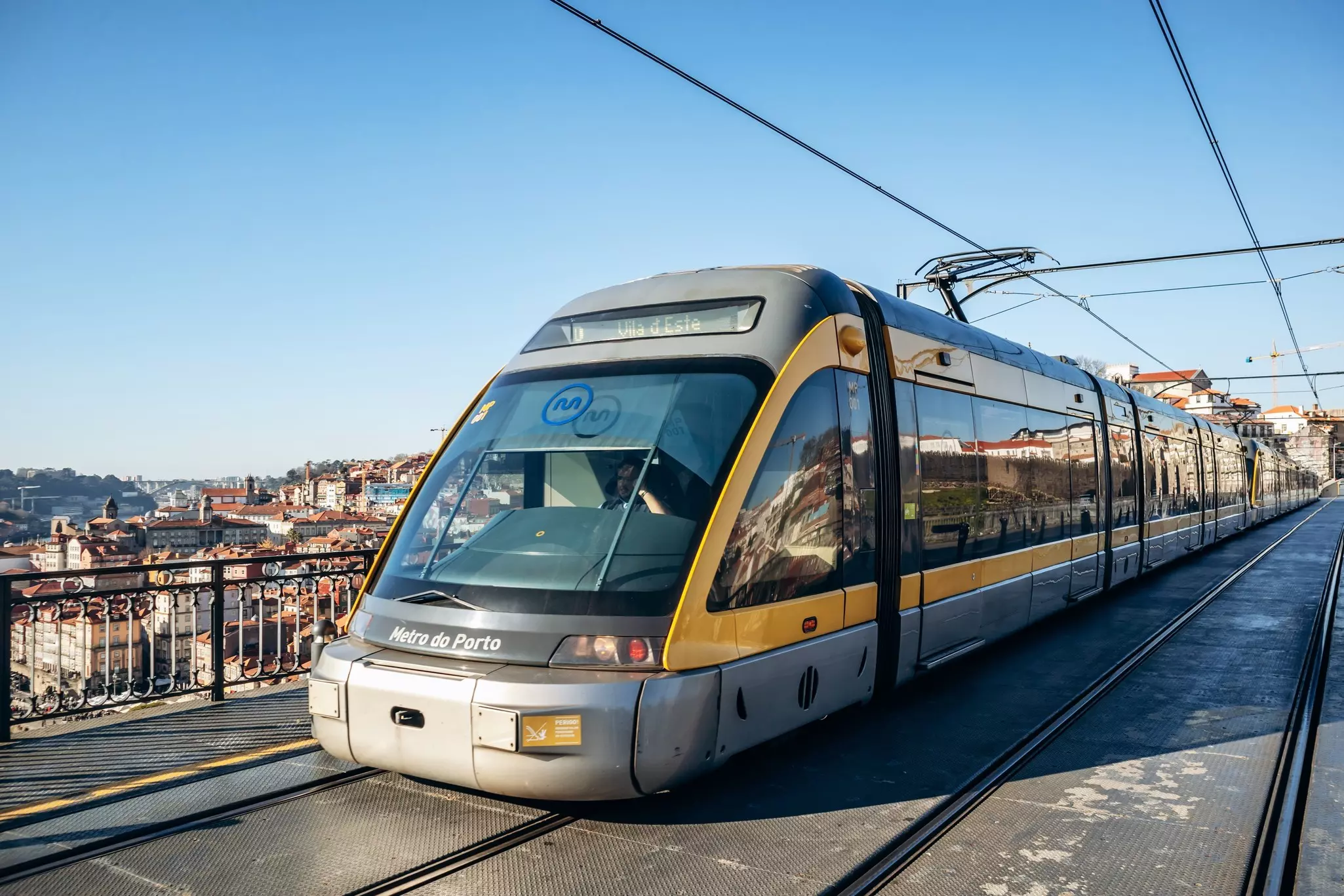 A sleek train crossing a bridge in a city