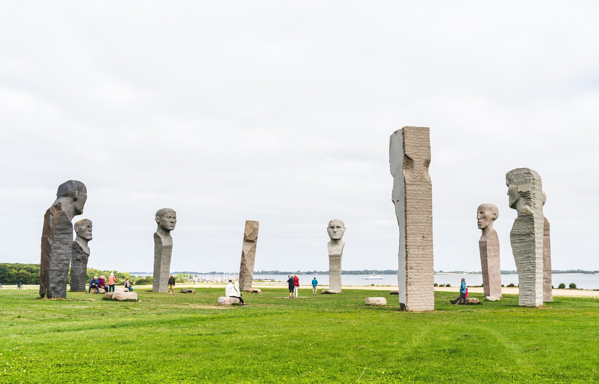 Tourists visiting the site of large stone statues on a summers day in Kragenes, Denmark.