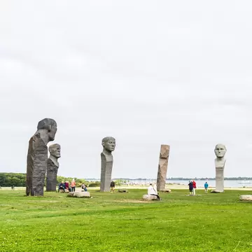 Tourists visiting the site of large stone statues on a summers day in Kragenes, Denmark.