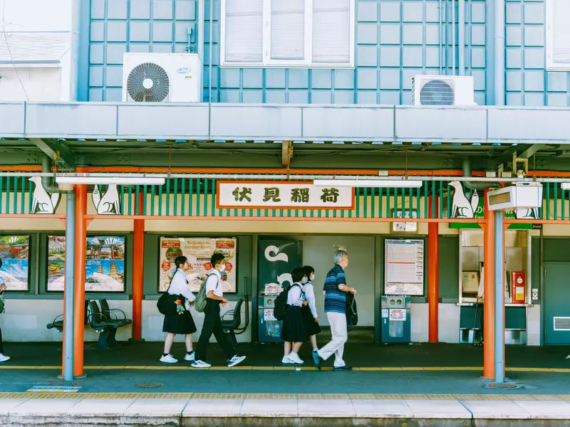 People pass through a train station wearing masks