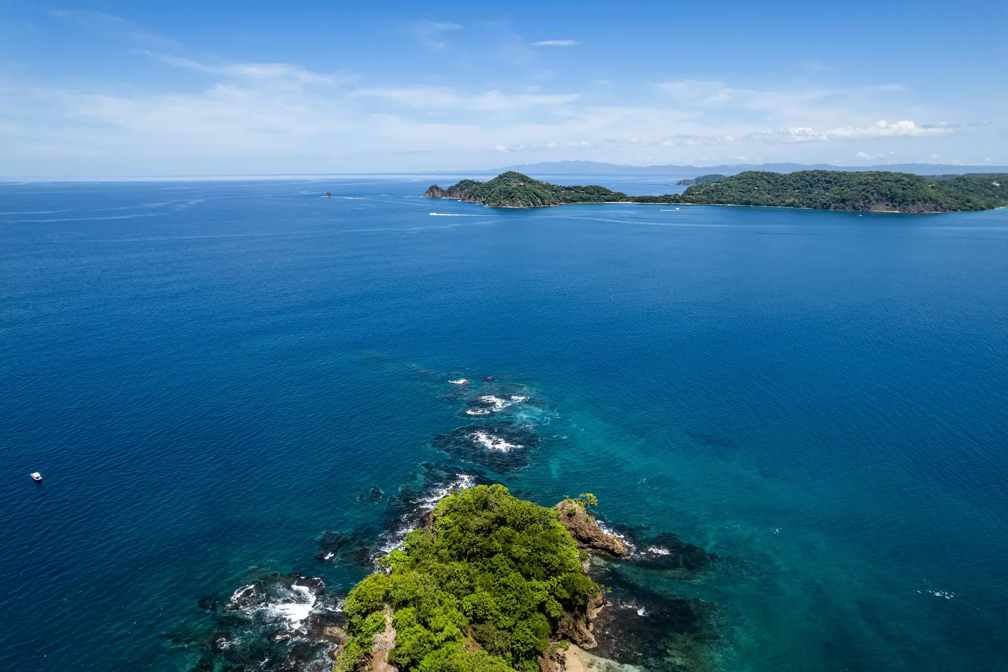 Beautiful aerial view of Playas del Coco, Hermosa Beach, and its green mountains, bay, and yachts in Costa Rica.
