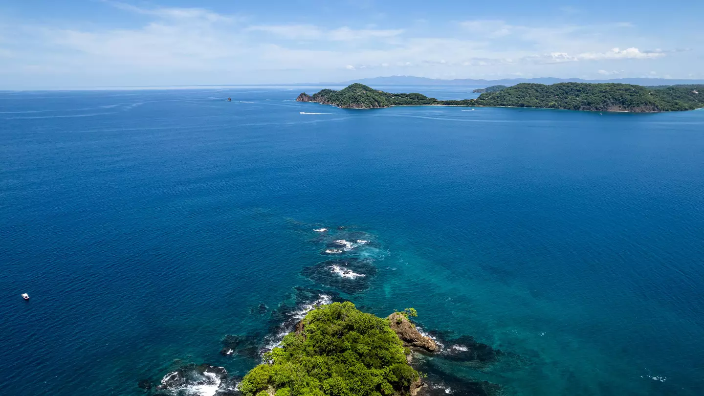 Beautiful aerial view of Playas del Coco, Hermosa Beach, and its green mountains, bay, and yachts in Costa Rica.