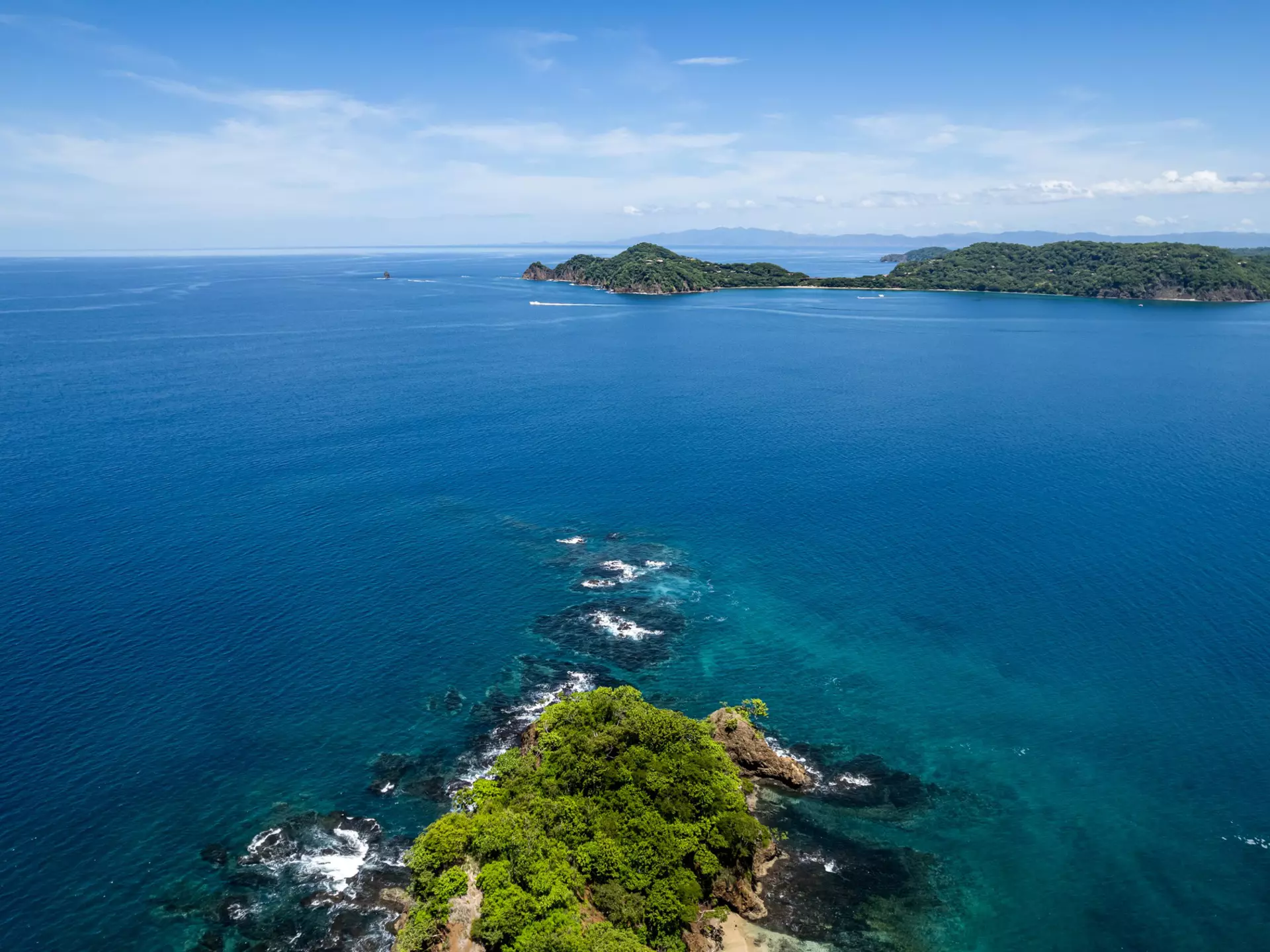 Beautiful aerial view of Playas del Coco, Hermosa Beach, and its green mountains, bay, and yachts in Costa Rica.