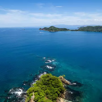 Beautiful aerial view of Playas del Coco, Hermosa Beach, and its green mountains, bay, and yachts in Costa Rica.