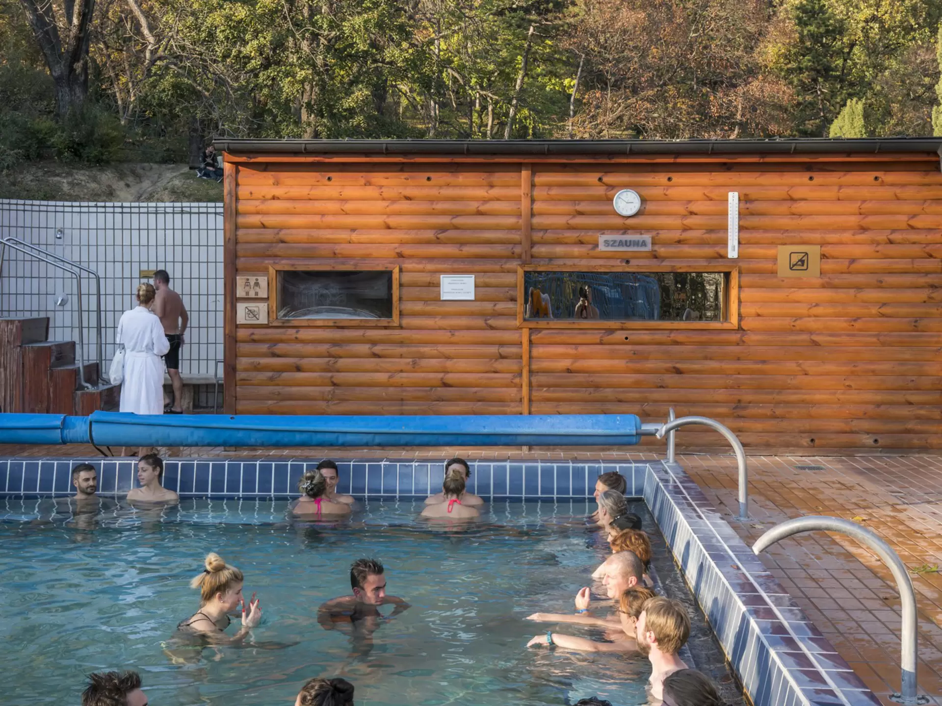 A group of people relax in an outdoor thermal bath.