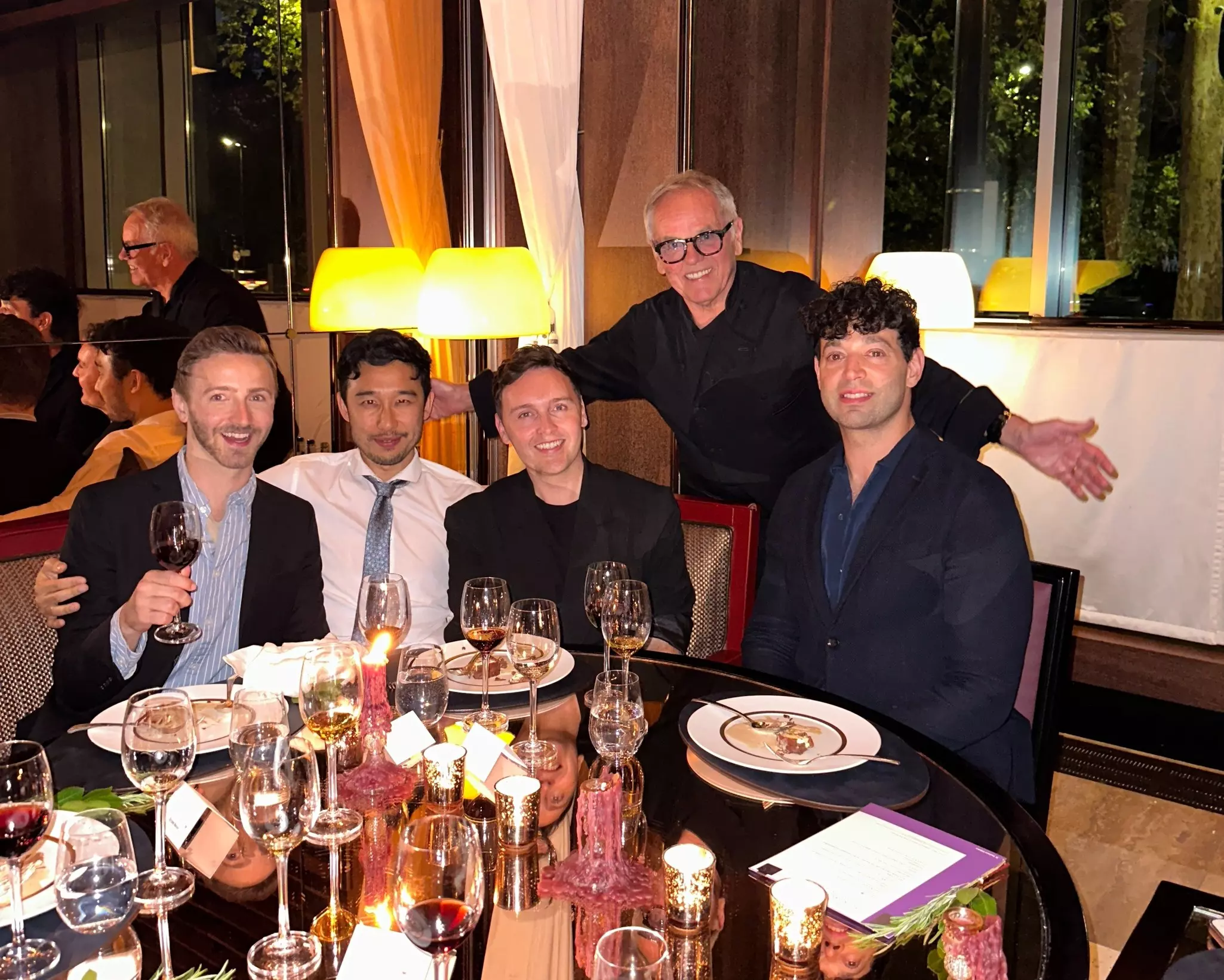 A group of male diners at a table of a fancy restaurant in London.