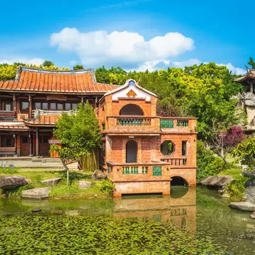 Lin An Tai Historical House and Museum surrounded by a pond and green trees in Taipei, Taiwan.
