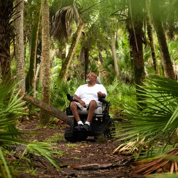 A man in a wheelchair in the woods at Myakka River State Park, Florida