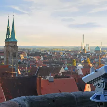 Telescope in Nuremberg castle and cityscape in background.