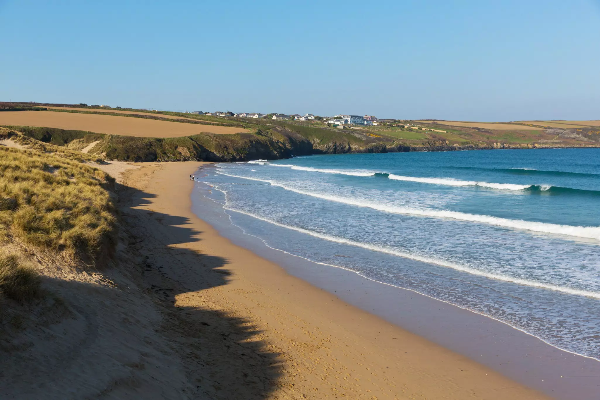 Crantock beach view to the headland with high tide surf, North Cornwall, England.