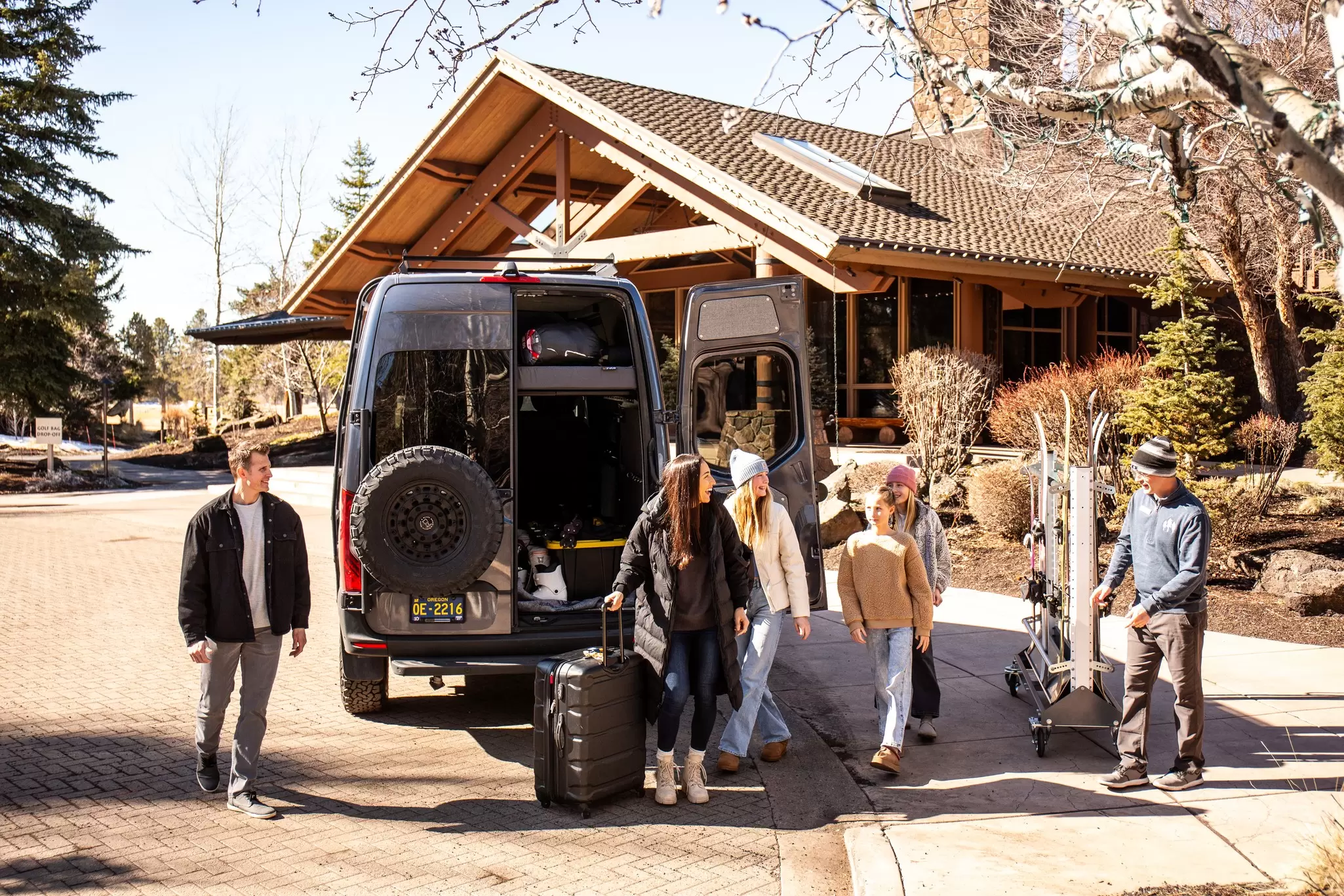 Group of guests outside Sunriver Resort with ski equipment and luggage in Sunriver, Oregon