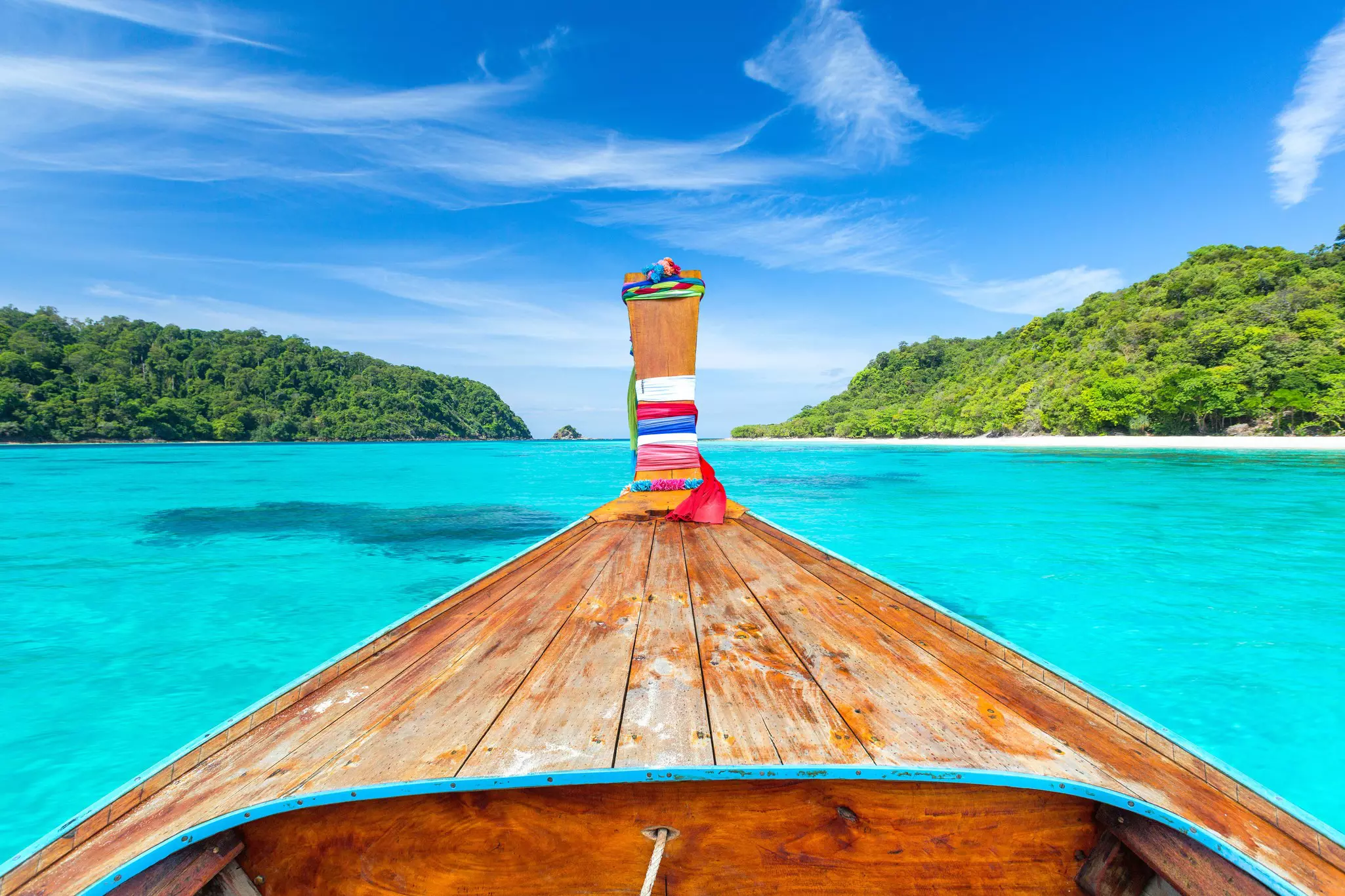 Long tail boat against blue sky and sea.