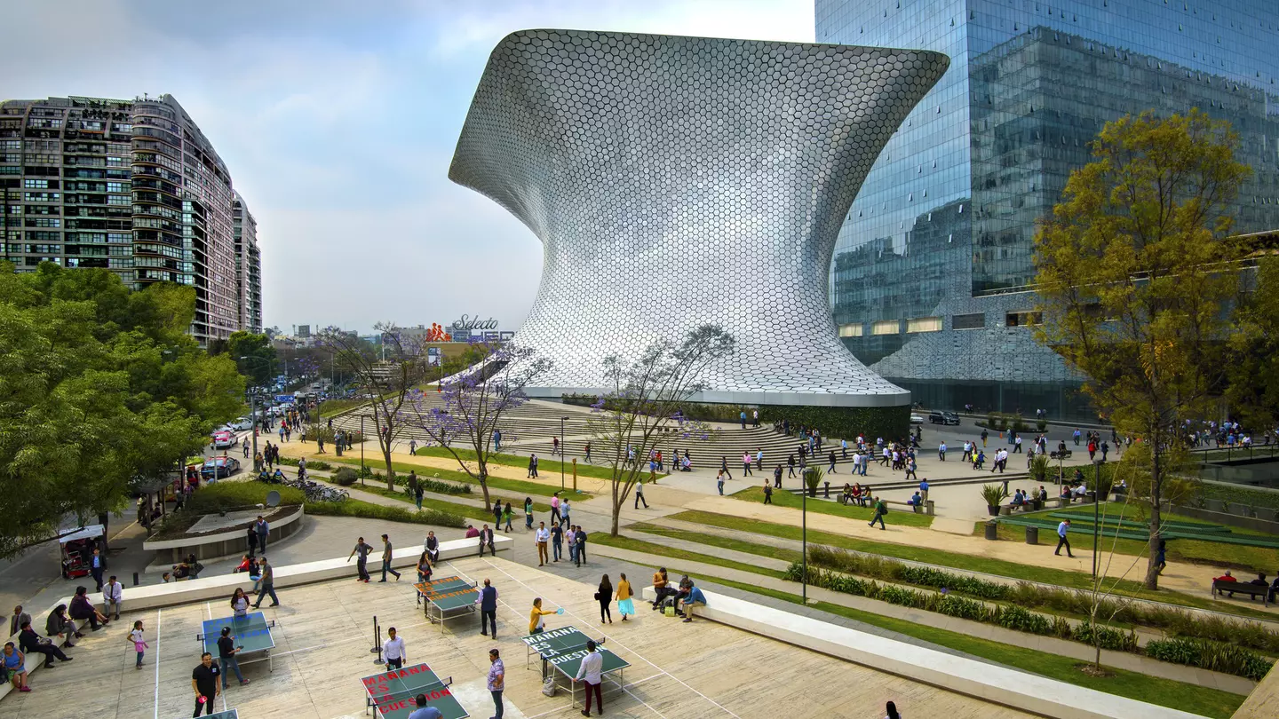 An overhead shot of workers on their lunch break enjoying a game of ping pong in front of the shiny, aluminum-paneled Soumaya Museum in Plaza Carso in the Polanco district of Mexico City.