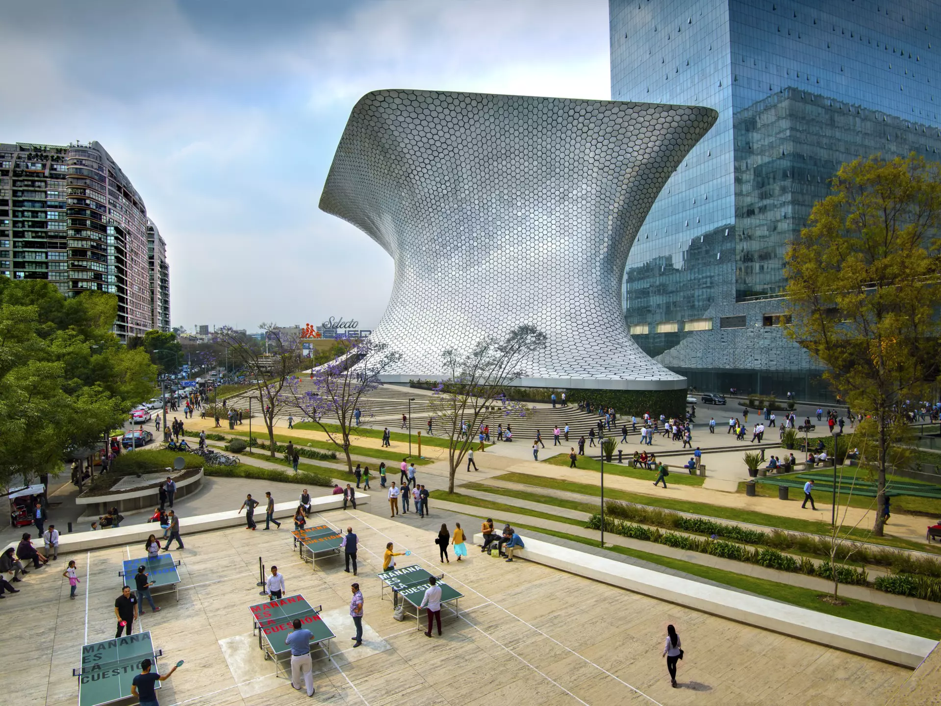 An overhead shot of workers on their lunch break enjoying a game of ping pong in front of the shiny, aluminum-paneled Soumaya Museum in Plaza Carso in the Polanco district of Mexico City.