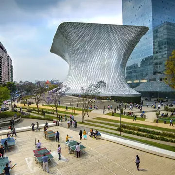 An overhead shot of workers on their lunch break enjoying a game of ping pong in front of the shiny, aluminum-paneled Soumaya Museum in Plaza Carso in the Polanco district of Mexico City.