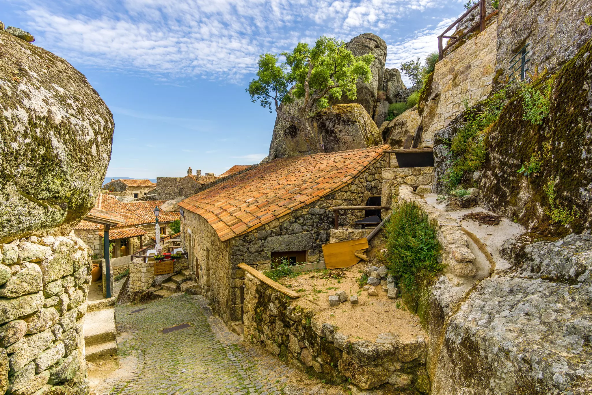 An ancient alleyway in a village with large boulders