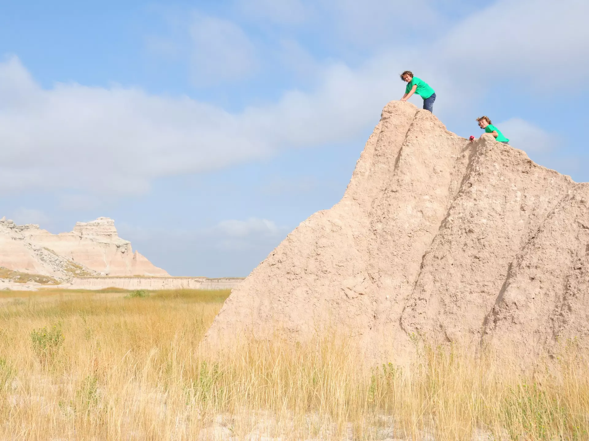 464476566
2015; Activity; Arid Climate; Badlands; Badlands National Park; Beauty In Nature; Blue; Boys; Brother; Caucasian Ethnicity; Child; Children Only; Desert; Diminishing Perspective; Drought; Dry; Empty; Environment; Famous Place; Footpath; Great Plains; Group Of People; Happiness; Heat; Heat - Temperature; Hiking; Hill; Horizontal; Journey; Landscape; Lifestyles; Loneliness; Males; Mountain; Mountain Range; National Park; Nature; Outdoors; People; Photography; Real People; Rear View; Scenics - Nature; South Dakota; The Americas; Togetherness; Travel; Travel Destinations; Two People; USA; Vacations; Vanishing Point; Walking; Weather; Wilderness Area;
Two young boys climbing a rock formation in Badlands National Park.