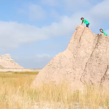 464476566
2015; Activity; Arid Climate; Badlands; Badlands National Park; Beauty In Nature; Blue; Boys; Brother; Caucasian Ethnicity; Child; Children Only; Desert; Diminishing Perspective; Drought; Dry; Empty; Environment; Famous Place; Footpath; Great Plains; Group Of People; Happiness; Heat; Heat - Temperature; Hiking; Hill; Horizontal; Journey; Landscape; Lifestyles; Loneliness; Males; Mountain; Mountain Range; National Park; Nature; Outdoors; People; Photography; Real People; Rear View; Scenics - Nature; South Dakota; The Americas; Togetherness; Travel; Travel Destinations; Two People; USA; Vacations; Vanishing Point; Walking; Weather; Wilderness Area;
Two young boys climbing a rock formation in Badlands National Park.