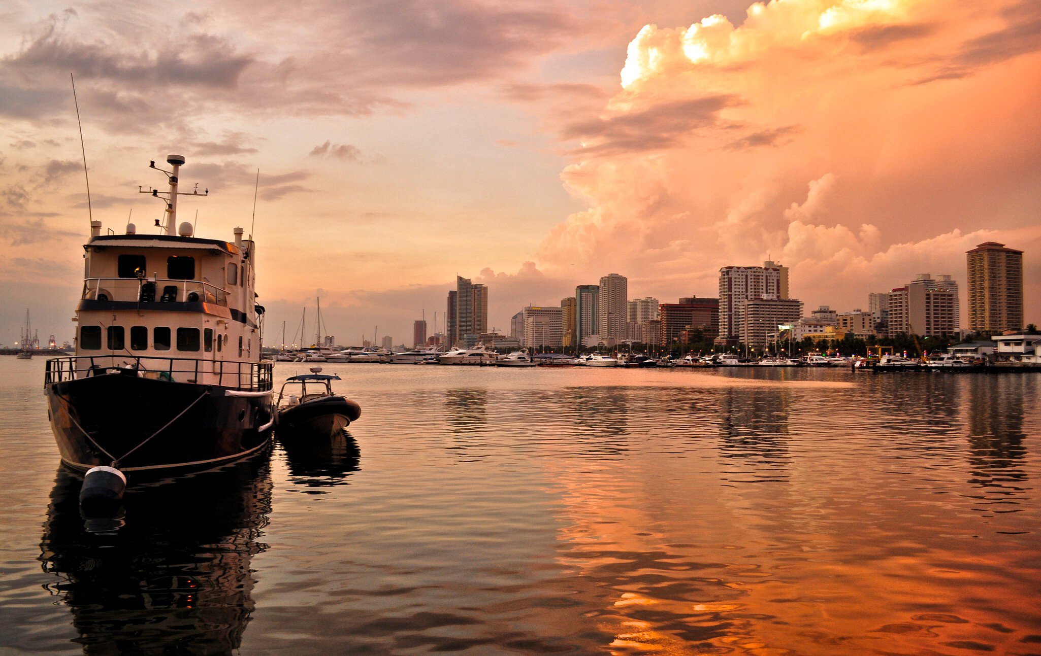 Skyline sit in golden reflective water at sunset.