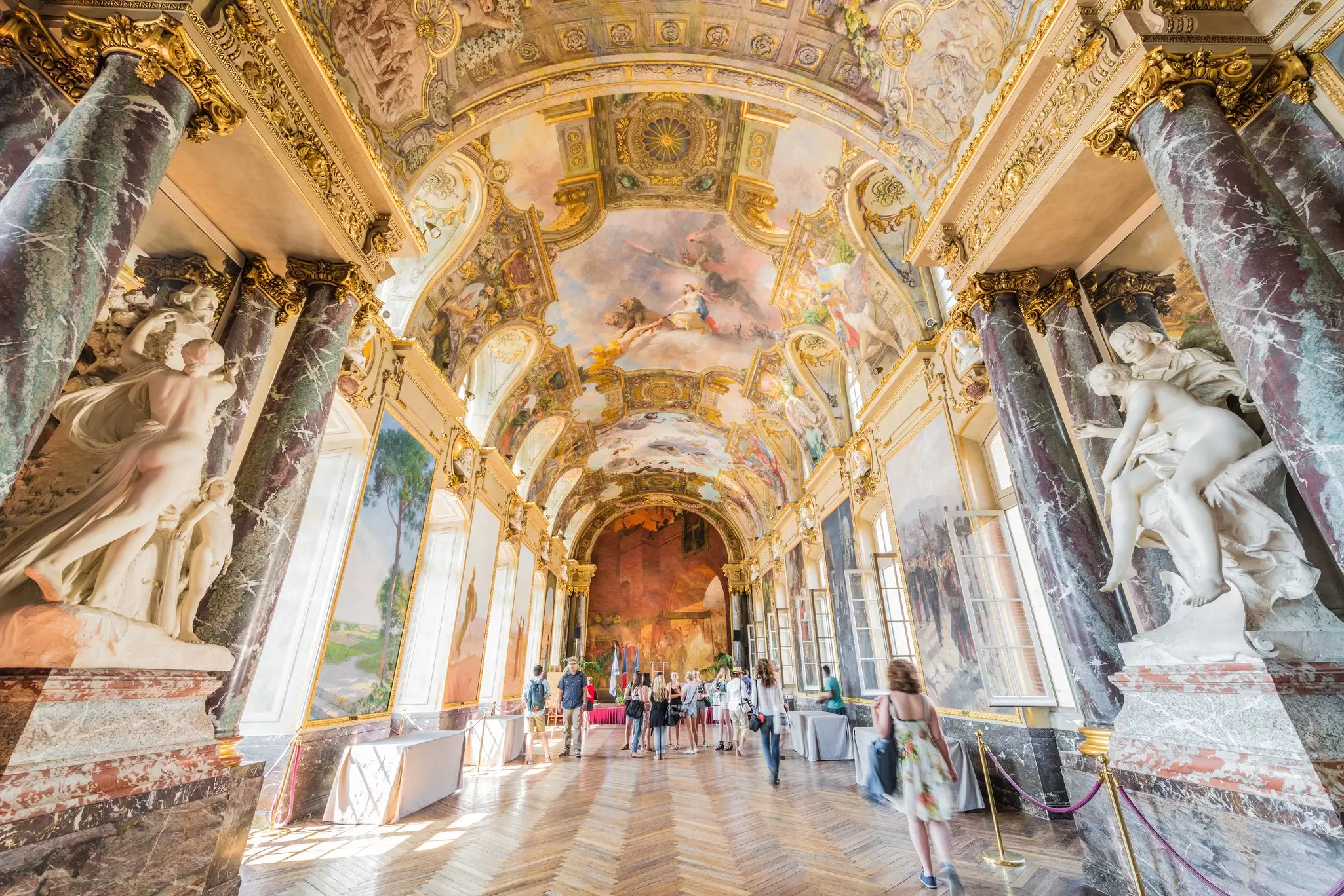interior view of Toulouse's Place du Capitole, a large airy hallway with colorful frescoes on the ceiling