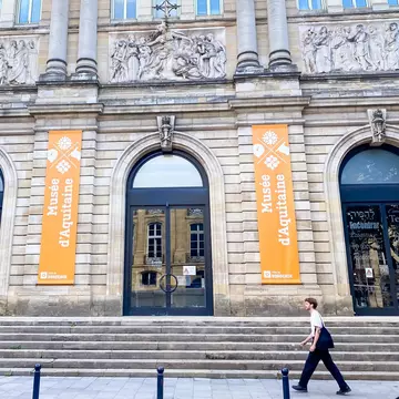 Exterior of the Musée d'Aquitaine museum in Bordeaux, France. Man walking past.