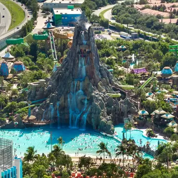 A vast artifical volcano-like structure forming a waterfall feature at a water park.