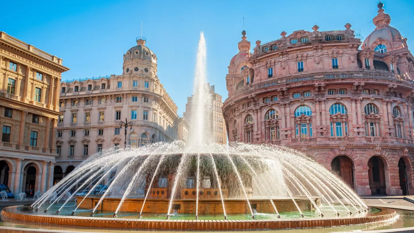 Fountain at the Piazza De Ferrari in Genoa, with ornate buildings in the background