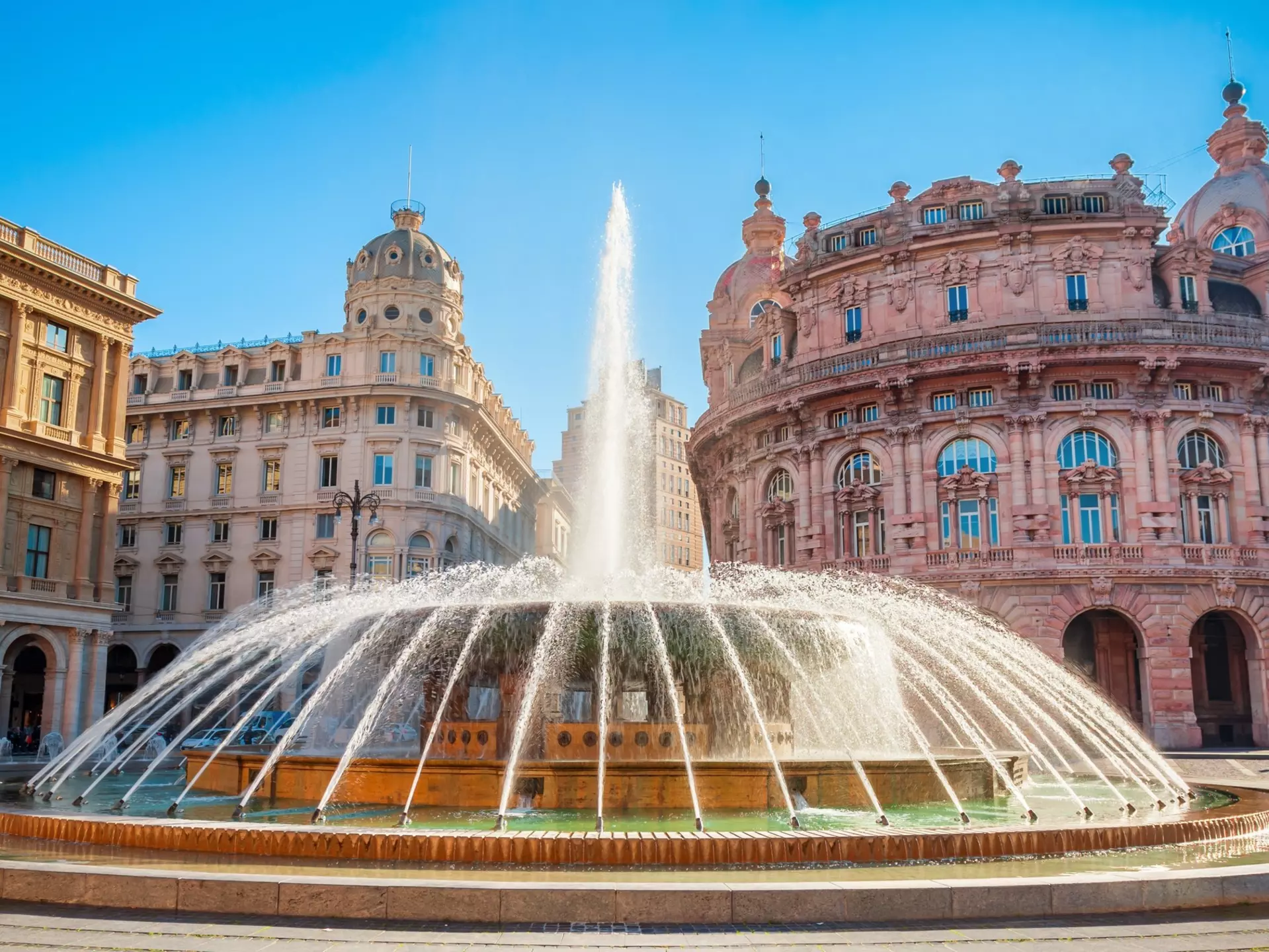 Fountain at the Piazza De Ferrari in Genoa, with ornate buildings in the background
