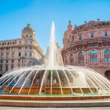 Fountain at the Piazza De Ferrari in Genoa, with ornate buildings in the background