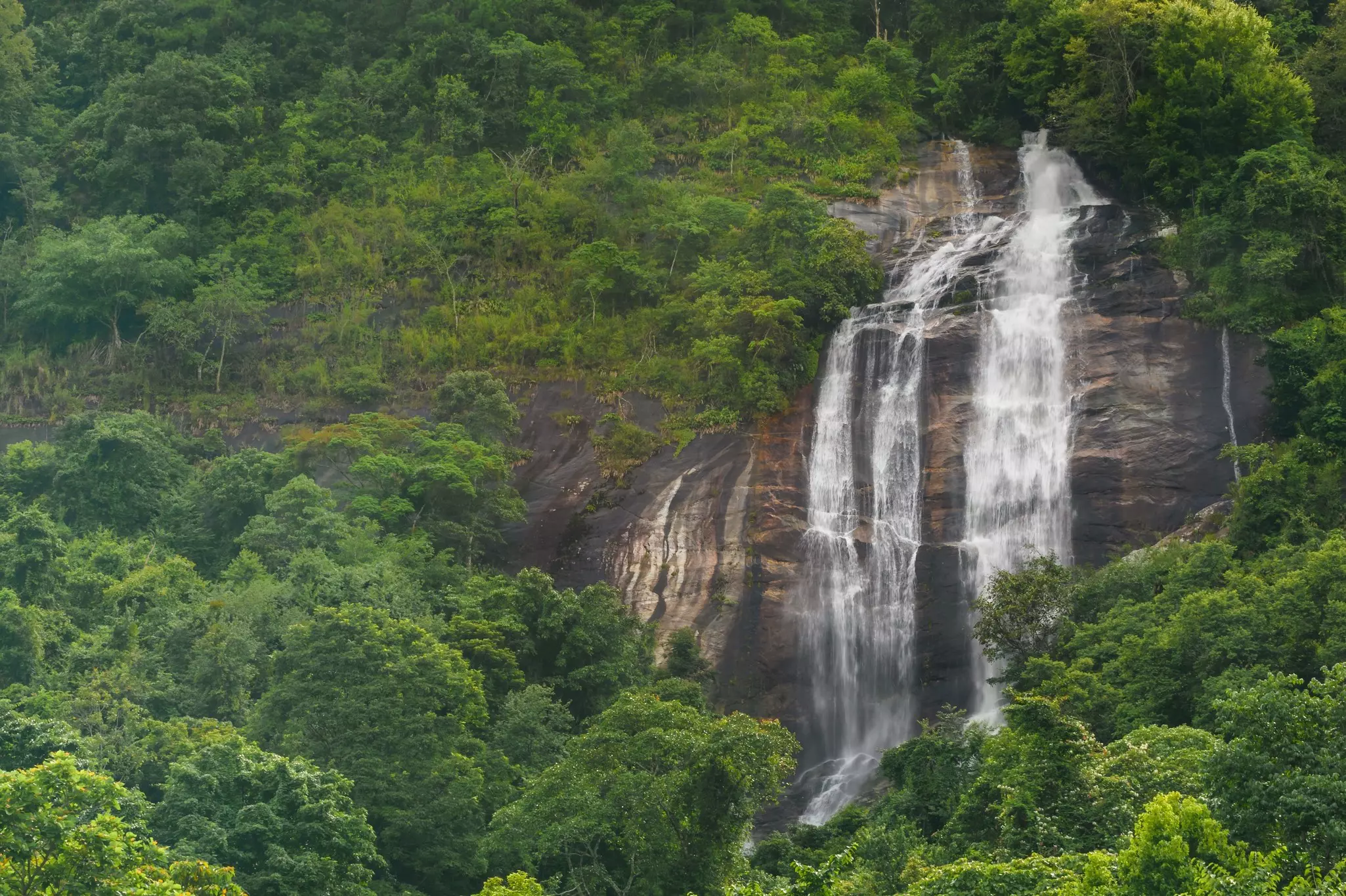 Siriphum Waterfall flows through the rocky cliffs in the forest near Chiang Mai, Thailand.