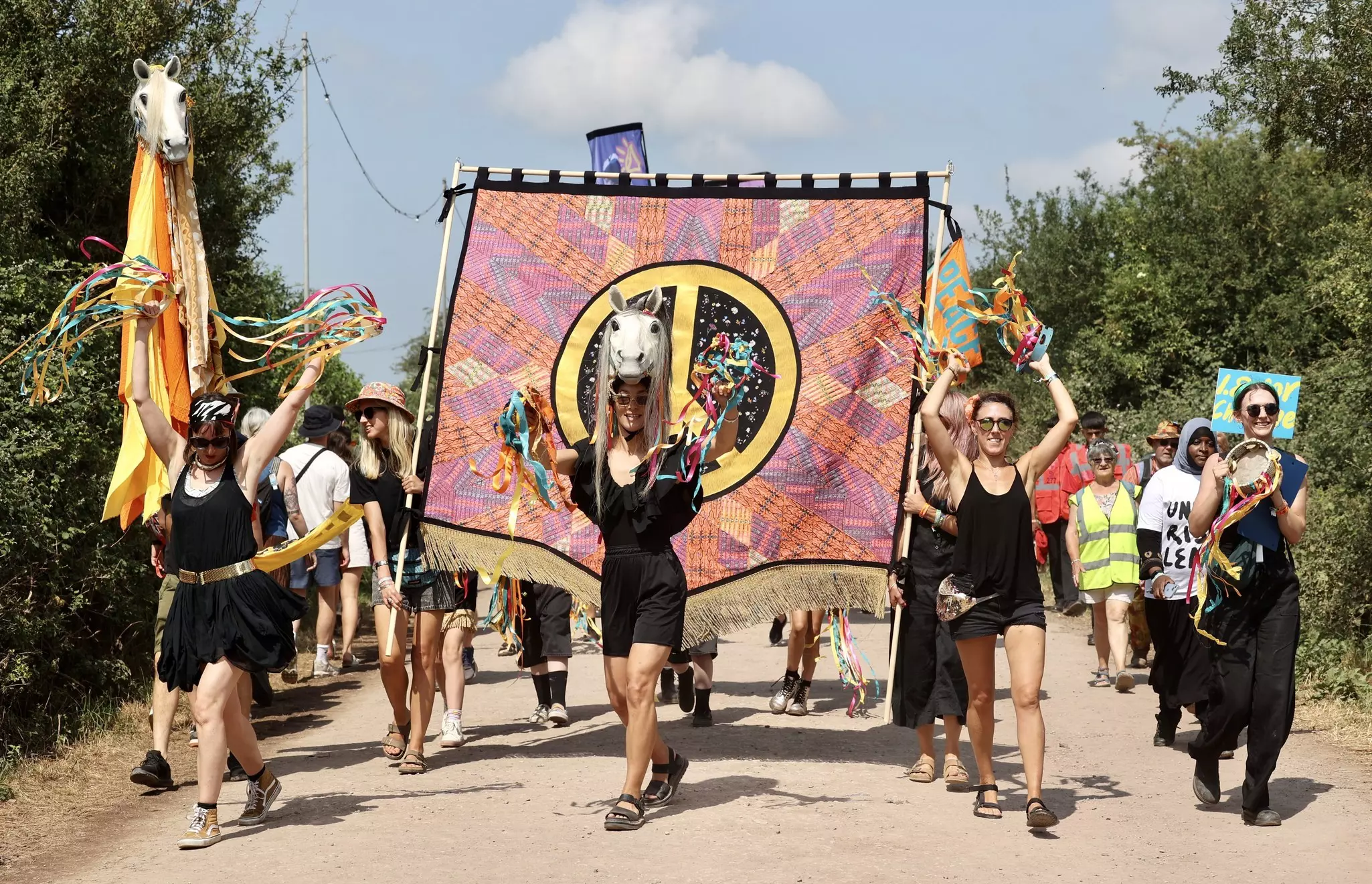 Women holding a banner at Glastonbury and having fun.