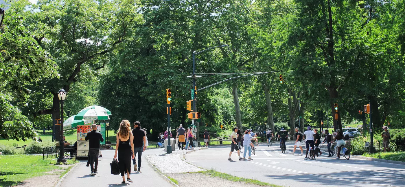 People walking and cycling on a road in Central Park, NYC