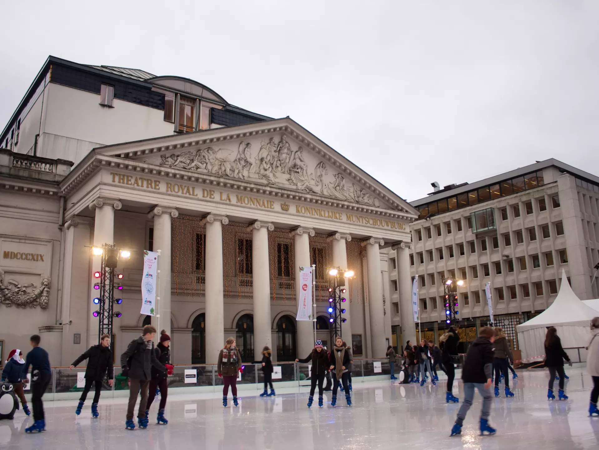 Ice-skaters on a rink in front of a building with columns in central Brussels.