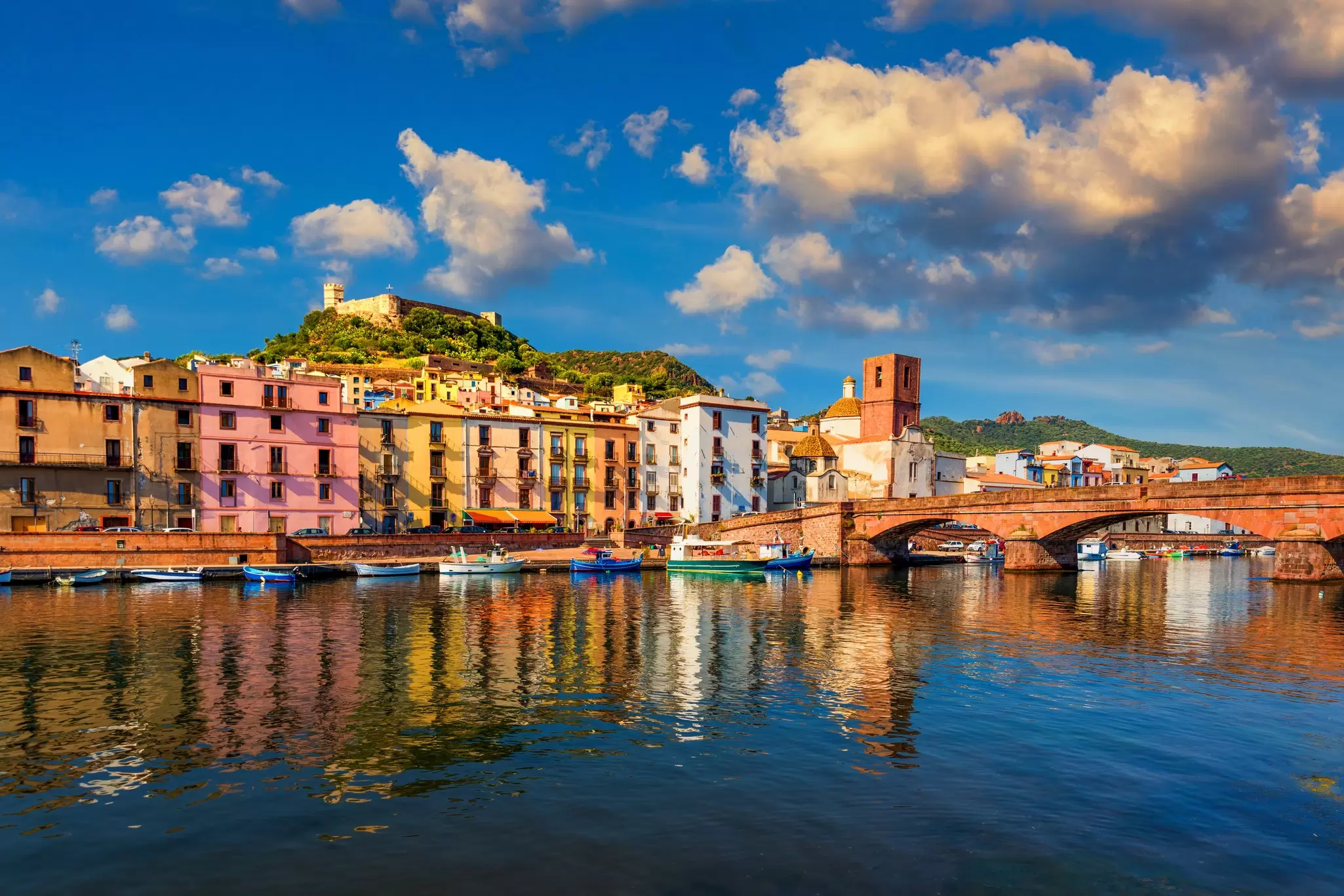 Colorful buildings lining a riverside and an ornate bridge over the water