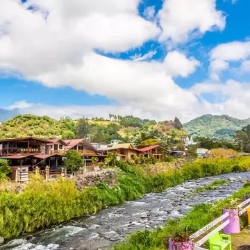 A river runs at the edge of a town in a rural area