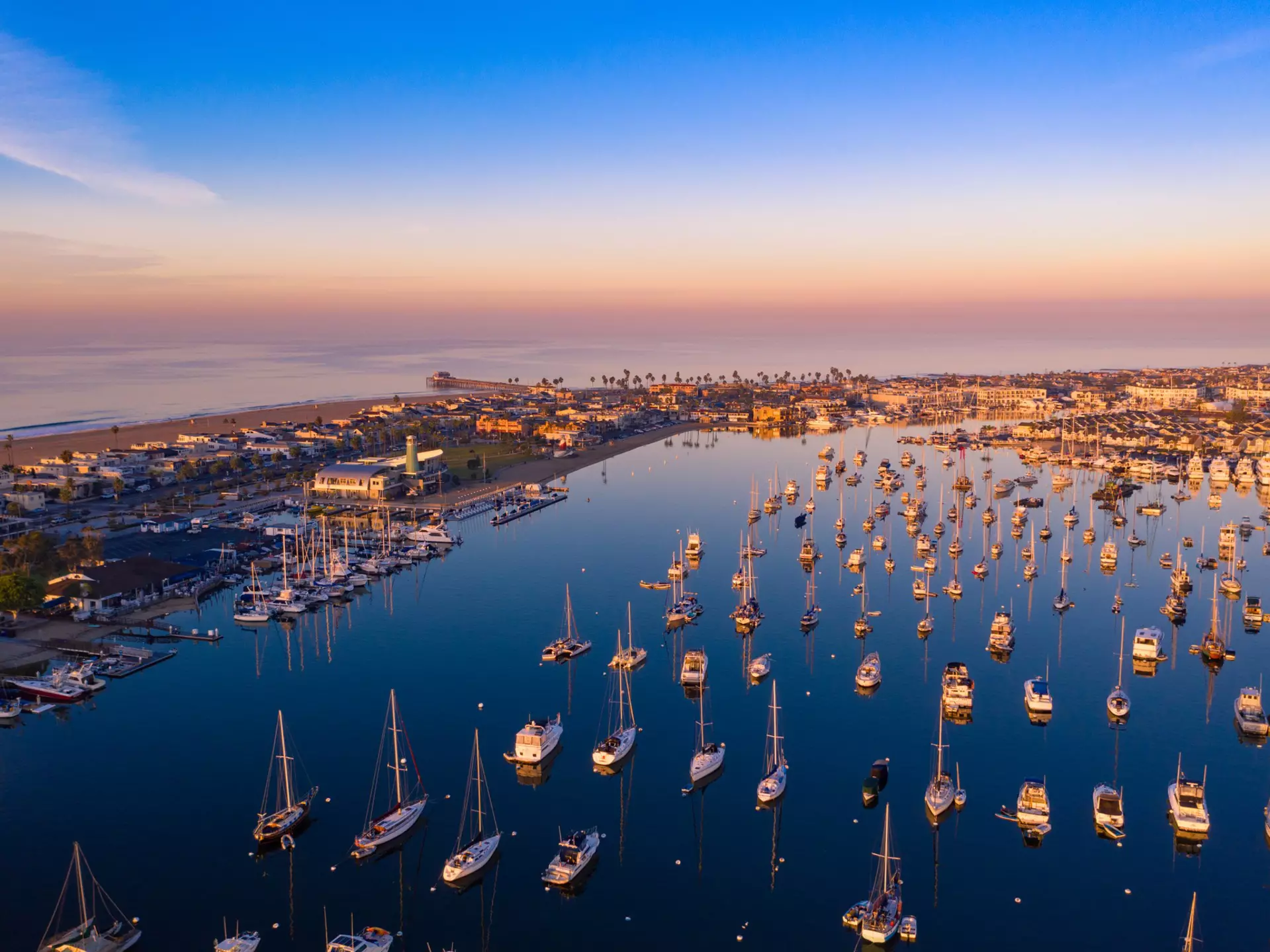 Aerial view of Newport Beach harbor in Orange County, California early in the morning with boats below.
