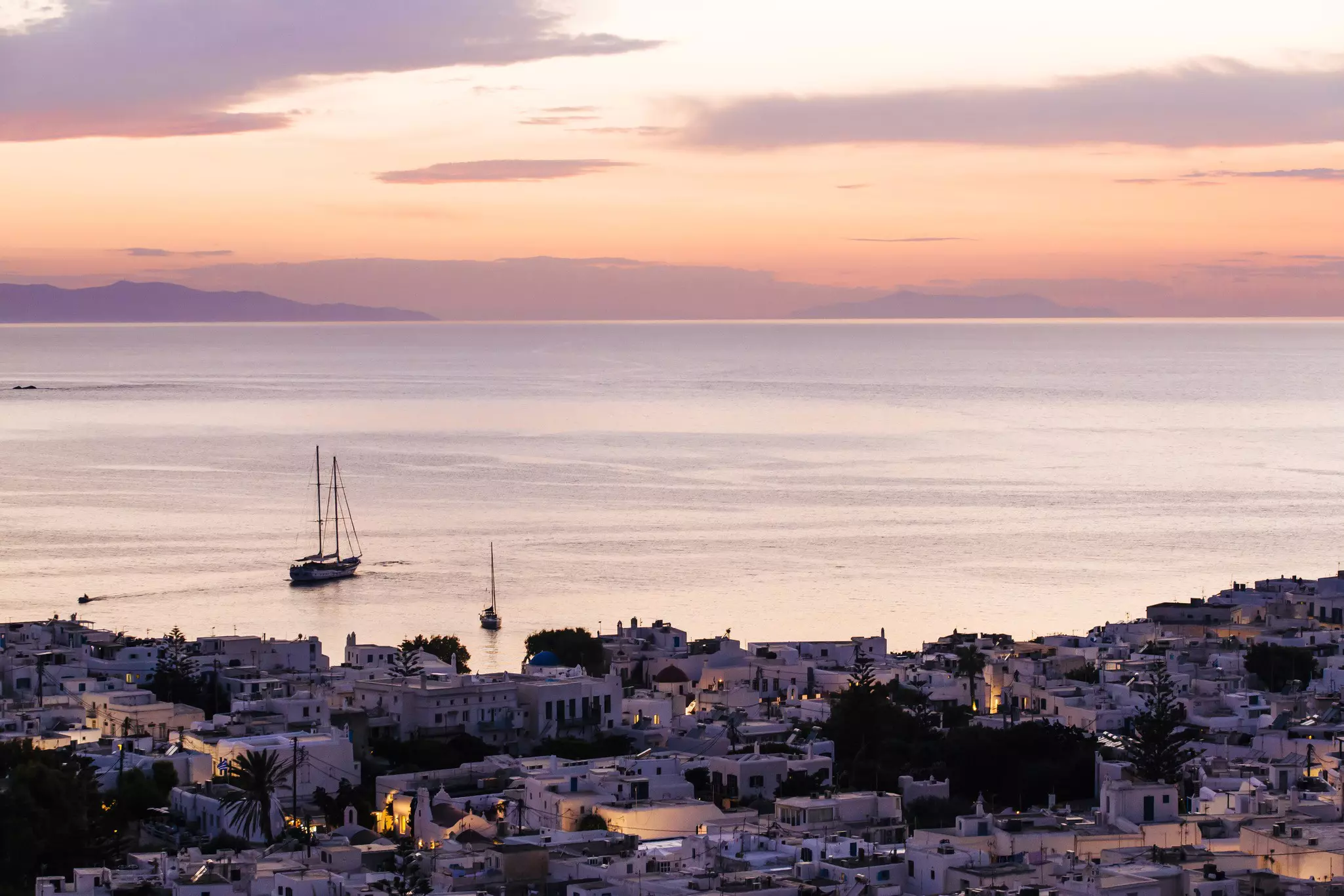 A sailboat at sunset off the coast of Mykonos