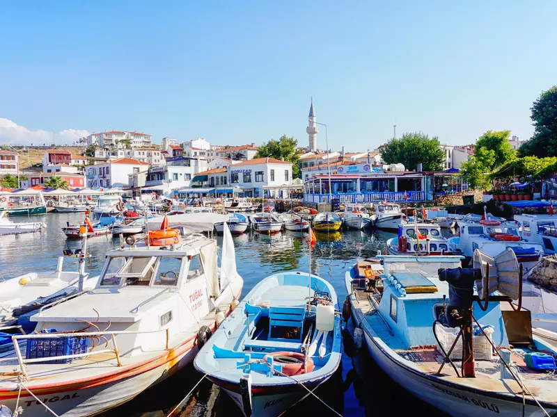 A port filled with boats and yachts overlooked by whitewashed buildings