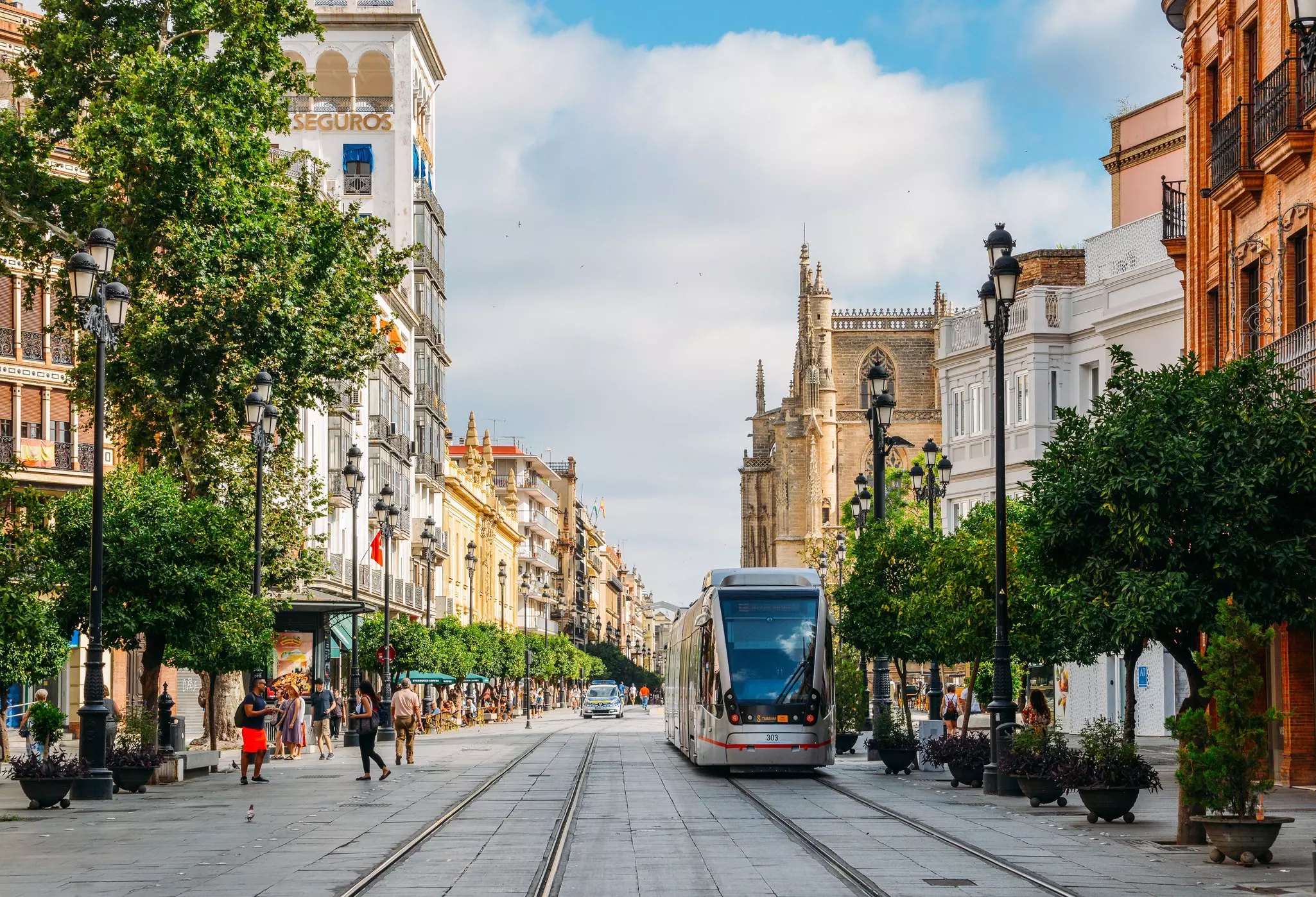 Seville, Spain - July 15, 2018: Electric tram on Constitution Avenue with iconic Seville Cathedral in background, License Type: media, Download Time: 2025-04-30T15:47:59.000Z, User: katelyn.perry_lonelyplanet, Editorial: true, purchase_order: 65050 - Digital Destinations and Articles, job: wip, client: wip, other: Katelyn Perry