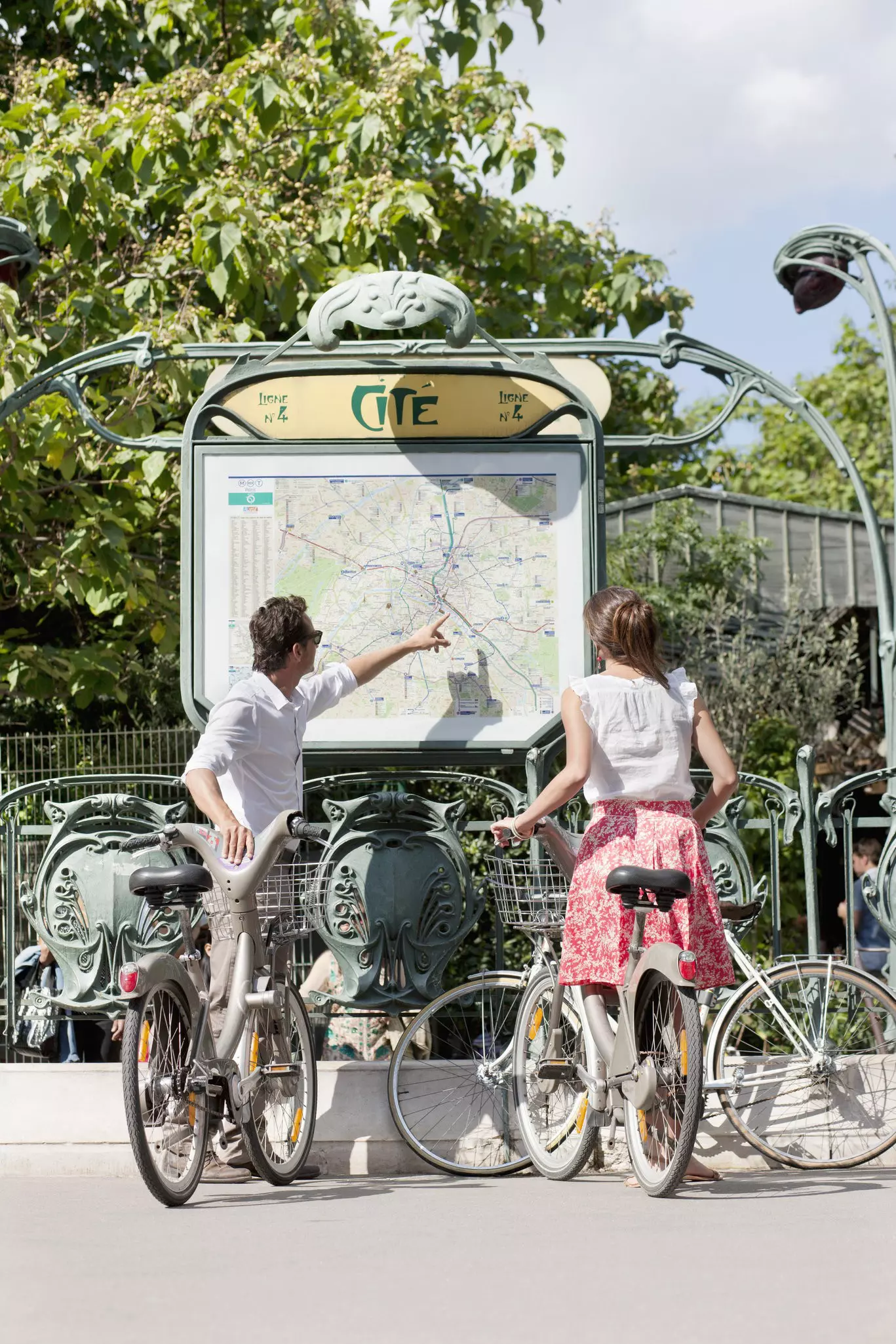 Couple with bicycles looking at a map, Paris, Ile-de-France, France