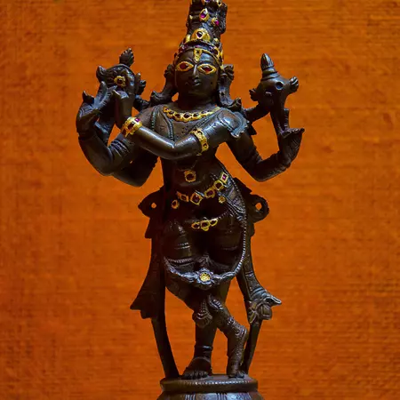 A sculpture of a deity adorned with gold and jewels.